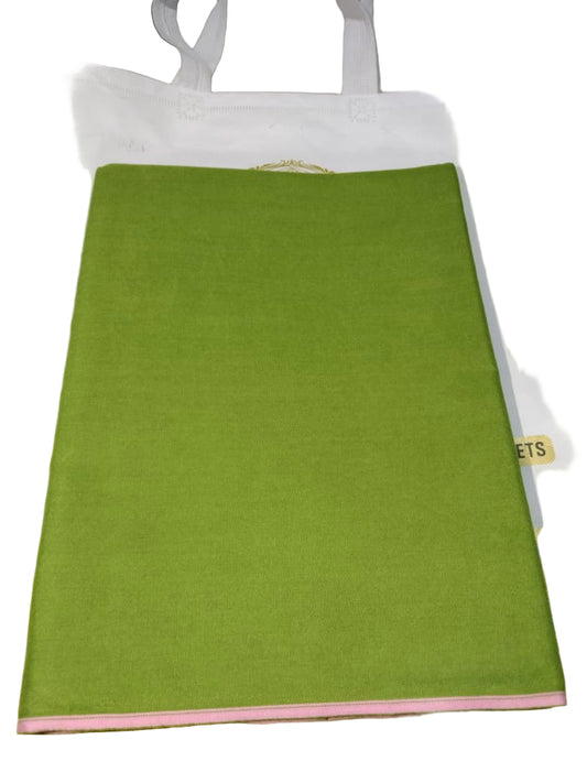 Green sheet of paper on a white surface with gold accents